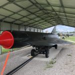 Three quarters view of the D-21 drone with the dark green color and red nose.