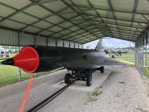 Three quarters view of the D-21 drone with the dark green color and red nose.
