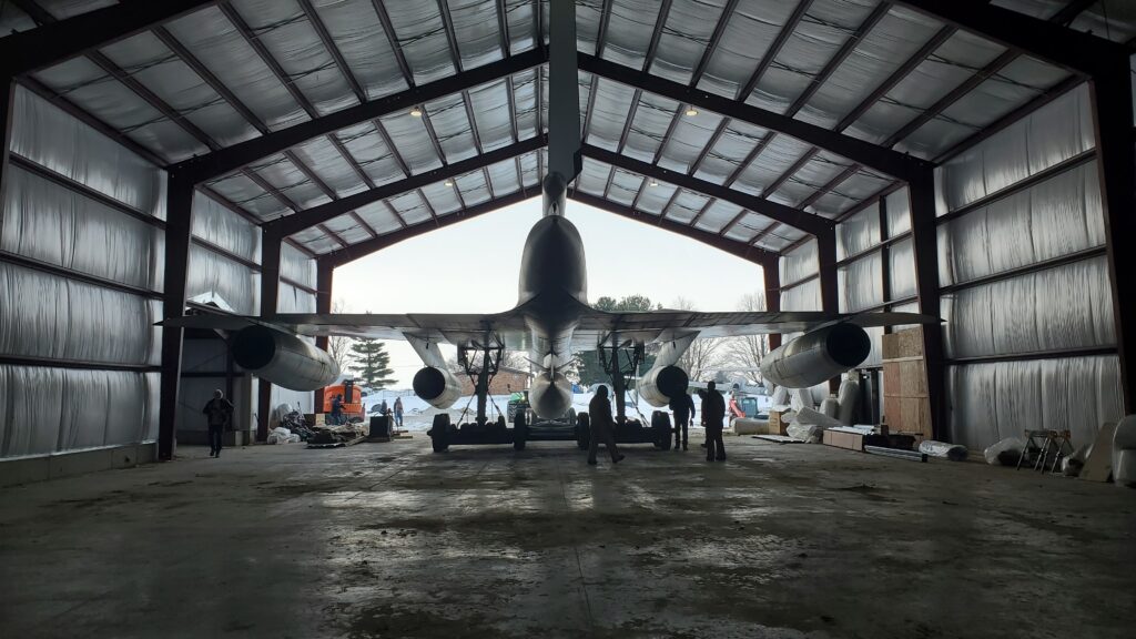 A picture show the B-58 being backed into the Cervantes Building, backlit by the daylight.