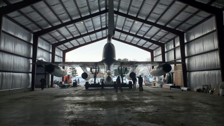 A picture show the B-58 being backed into the Cervantes Building, backlit by the daylight.