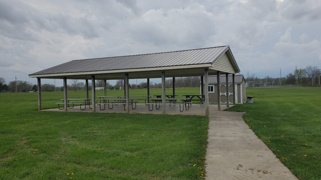 Open air (no walls, just roof) picnic pavilion with its storage unit behind it.