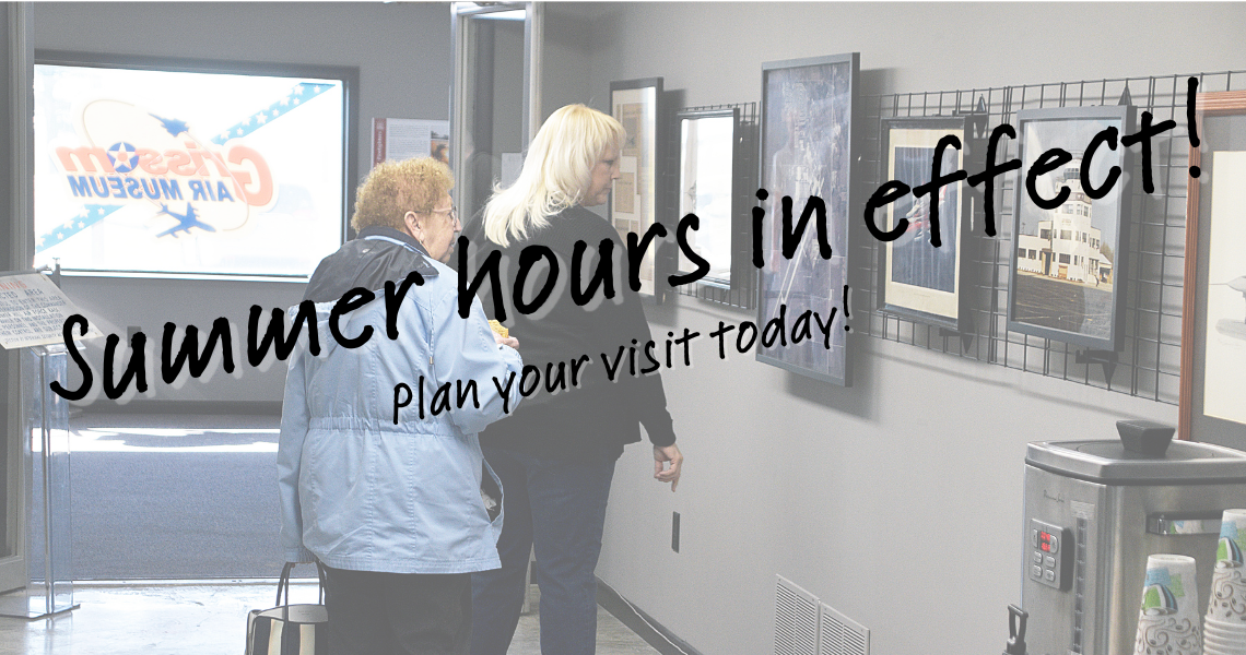 Two women looking at an exhibit inside the museum with text overlay saying "Summer Hours in Effect; Plan your visit today"