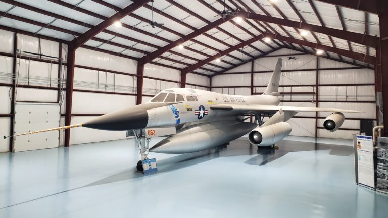 3/4 side view of the B-58 inside the Cervantes Building, fully lit with its new blue epoxy floor.