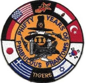 Military patch with the Spook character in the middle surrounded by the flags of countries who flew the F-4s and includes the phrase "Phifty Years of Phabulous Phantoms"
